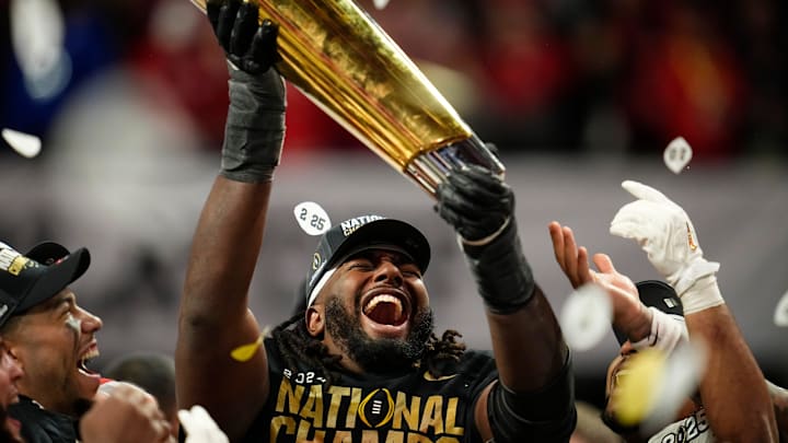 Ohio State Buckeyes offensive lineman Donovan Jackson (74) holds the trophy following the 34-23 win over the Notre Dame Fighting Irish to win the College Football Playoff National Championship at Mercedes-Benz Stadium in Atlanta on Jan. 21, 2025.