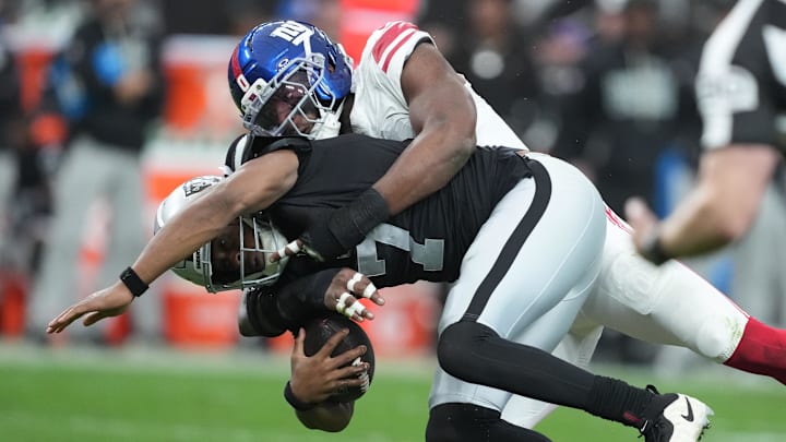 Dec 28, 2025; Paradise, Nevada, USA; Las Vegas Raiders quarterback Geno Smith (7) is tackled by New York Giants outside linebacker Brian Burns (0) in the second half at Allegiant Stadium. Mandatory Credit: Kirby Lee-Imagn Images