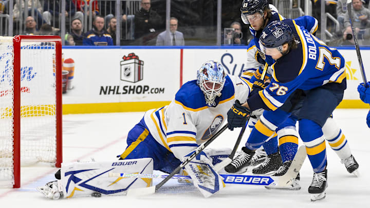Dec 29, 2024; St. Louis, Missouri, USA;  Buffalo Sabres goaltender Ukko-Pekka Luukkonen (1) defends the net against St. Louis Blues center Zack Bolduc (76) and left wing Jake Neighbours (63) during the second period at Enterprise Center. Mandatory Credit: Jeff Curry-Imagn Images