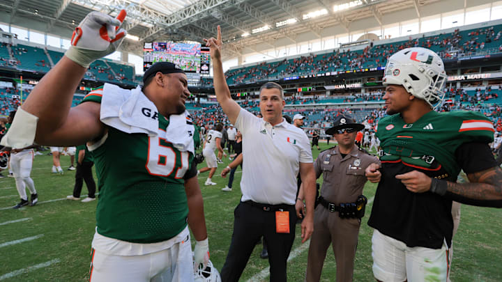 Nov 23, 2024; Miami Gardens, Florida, USA; Miami Hurricanes head coach Mario Cristobal celebrates with Miami Hurricanes offensive lineman Francis Mauigoa (61) and tight end Elijah Arroyo (8) after the game against the Wake Forest Demon Deacons at Hard Rock Stadium. Mandatory Credit: Sam Navarro-Imagn Images