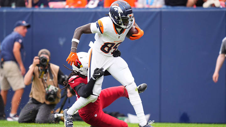 Aug 25, 2024; Denver, Colorado, USA; Arizona Cardinals safety Andre Chachere (36) tackles Denver Broncos wide receiver Brandon Johnson (89) in the second half at Empower Field at Mile High. Mandatory Credit: Ron Chenoy-Imagn Images