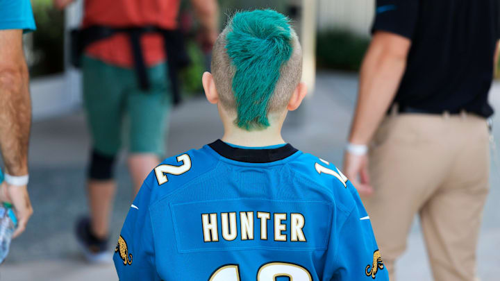 Easton Brown, 9, of Neptune Beach walks with blue mohawk and Jacksonville Jaguars Travis Hunter (12) jersey during the second mandatory minicamp at Miller Electric Center Wednesday, June 11, 2025 in Jacksonville, Fla. Easton Brown, 9, of Neptune Beach walks with blue mohawk and Jacksonville Jaguars Travis Hunter (12) jersey during the second mandatory minicamp at Miller Electric Center Wednesday, June 11, 2025 in Jacksonville, Fla.