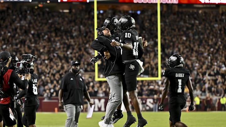 Oct 26, 2024; College Station, Texas, USA; Texas A&M Aggies quarterback Marcel Reed (10) celebrates after scoring a touchdown with Offensive Coordinator/Quarterbacks coach Collin Klein in the third quarter against the LSU Tigers at Kyle Field. Mandatory Credit: Maria Lysaker-Imagn Images. 