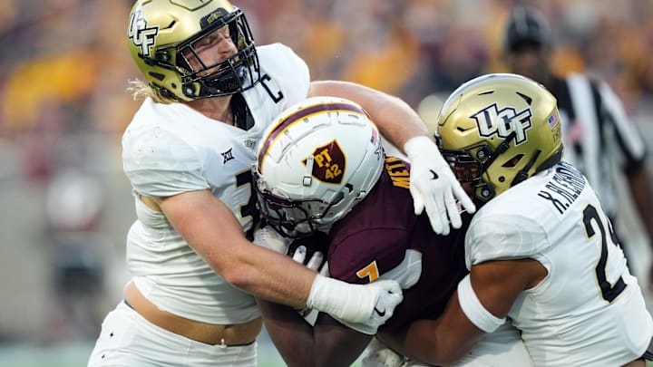 UCF Knights linebackers Ethan Barr adn Xe'ree Alexander, a one-time UW signee and a current one, tackle an ASU opponent. 