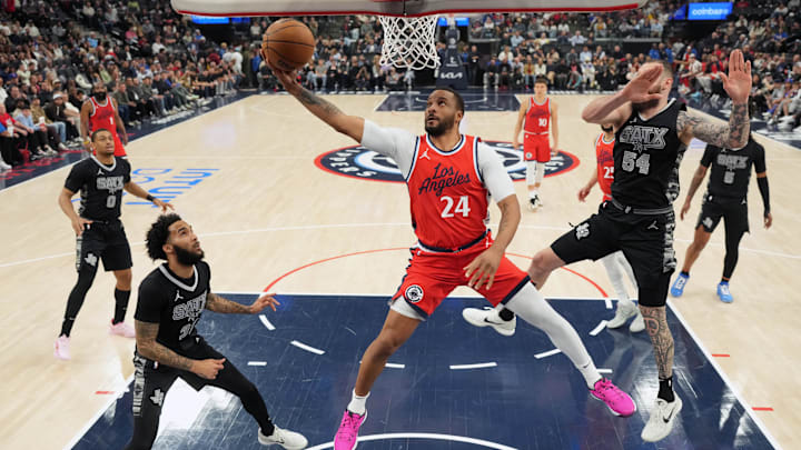 Apr 8, 2025; Inglewood, California, USA; LA Clippers guard Norman Powell (24) shoots the ball against San Antonio Spurs forward Julian Champagnie (30) and forward Sandro Mamukelashvili (54) in the first half at Intuit Dome. Mandatory Credit: Kirby Lee-Imagn Images