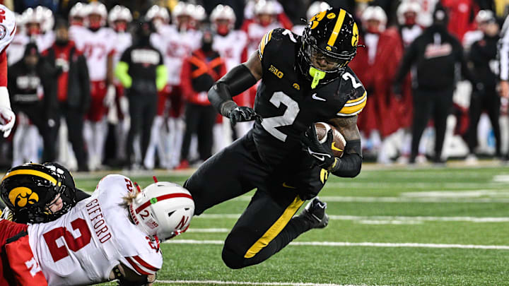 Nov 29, 2024; Iowa City, Iowa, USA; Iowa Hawkeyes running back Kaleb Johnson (2) runs the ball as Nebraska Cornhuskers defensive back Isaac Gifford (2) makes the tackle during the third quarter at Kinnick Stadium. Mandatory Credit: Jeffrey Becker-Imagn Images