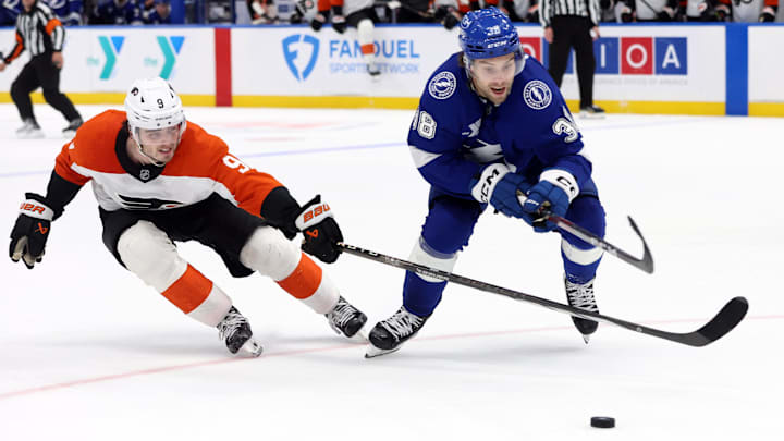 Nov 7, 2024; Tampa, Florida, USA; Tampa Bay Lightning left wing Brandon Hagel (38) and Philadelphia Flyers defenseman Jamie Drysdale (9) fight to control the puck during overtime at Amalie Arena.