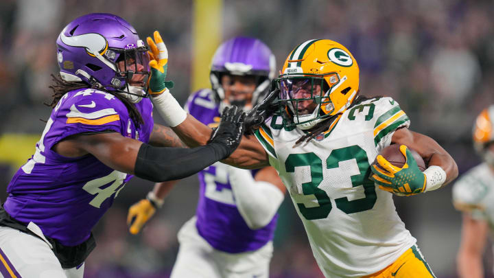 Dec 31, 2023; Minneapolis, Minnesota, USA; Green Bay Packers running back Aaron Jones (33) runs with the ball against the Minnesota Vikings safety Josh Metellus (44) in the first quarter at U.S. Bank Stadium. Dec 31, 2023; Minneapolis, Minnesota, USA; Green Bay Packers running back Aaron Jones (33) runs with the ball against the Minnesota Vikings safety Josh Metellus (44) in the first quarter at U.S. Bank Stadium.