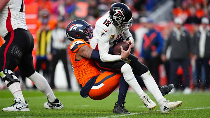 Nov 17, 2024; Denver, Colorado, USA; Denver Broncos linebacker Nik Bonitto (15) sacks Atlanta Falcons quarterback Kirk Cousins (18) in the second half at Empower Field at Mile High.