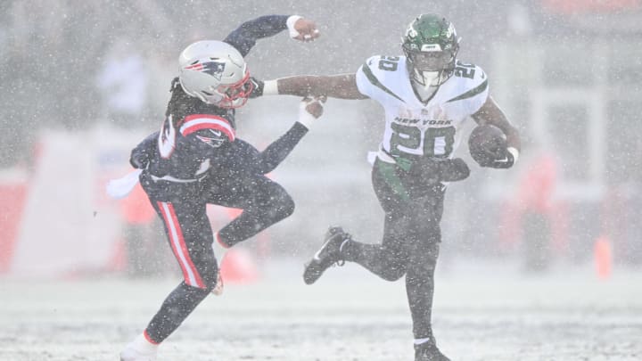 Jan 7, 2024; Foxborough, Massachusetts, USA; New York Jets running back Breece Hall (20) breaks a tackle from New England Patriots safety Kyle Dugger (23) during the first half at Gillette Stadium. Mandatory Credit: Brian Fluharty-Imagn Images