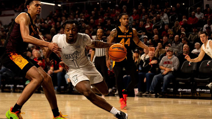 Cincinnati Bearcats guard Day Day Thomas (1) drives on Arizona State Sun Devils forward Basheer Jihad (8) in the second half of the NCAA basketball game at Fifth Third Arena in Cincinnati on Saturday, January 18, 2025.