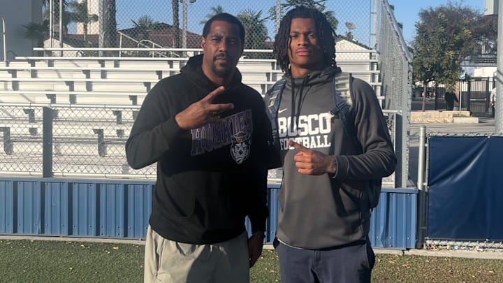 UW receivers coach Kevin Cummings with Daniel Odom of St. John Bosco High in January.