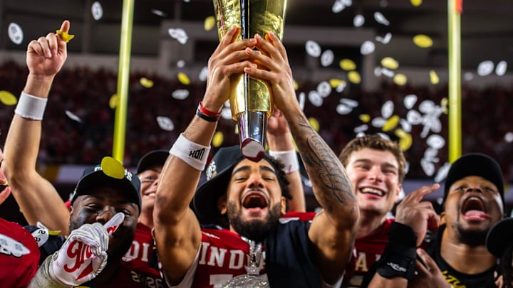 Indiana's Elijah Sarratt (13) lifts the trophy as Tyrique Tucker (95), Charlie Becker (80), Fernando Mendoza (15), and Mikail Kamara (6) celebrate on the podium after the College Football Playoff National Championship college football game at Hard Rock Stadium in Miami Gardens on Monday, Jan. 19, 2026. Indiana's Elijah Sarratt (13) lifts the trophy as Tyrique Tucker (95), Charlie Becker (80), Fernando Mendoza (15), and Mikail Kamara (6) celebrate on the podium after the College Football Playoff National Championship college football game at Hard Rock Stadium in Miami Gardens on Monday, Jan. 19, 2026.