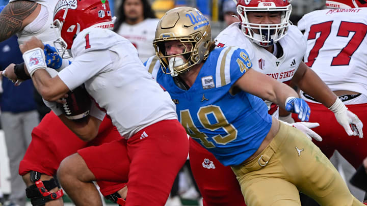 Nov 30, 2024; Pasadena, California, USA; UCLA Bruins linebacker Carson Schwesinger (49) sacks Fresno State Bulldogs quarterback Mikey Keene (1) during the second quarter at Rose Bowl. Mandatory Credit: Robert Hanashiro-Imagn Images