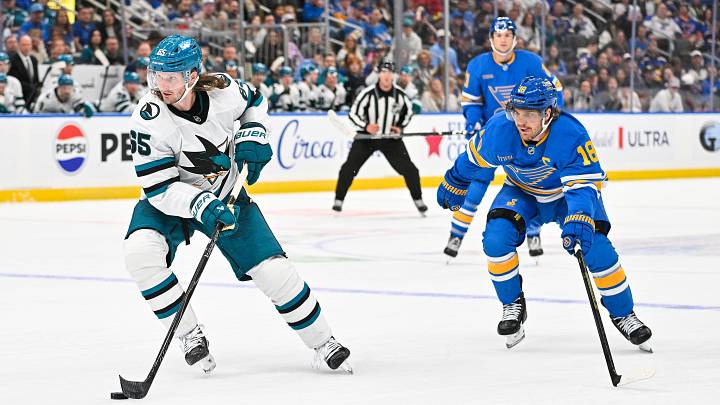 Oct 8, 2026; St. Louis, Missouri, USA; San Jose Sharks defenseman Jacob Trouba (65) controls the puck as St. Louis Blues center Robert Thomas (18) defends during overtime at Enterprise Center. Mandatory Credit: Jeff Curry-Imagn Images