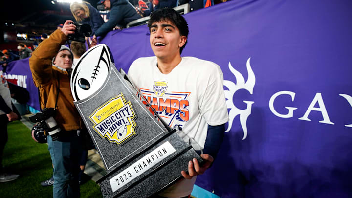 Illinois kicker David Olano (24) carries the Music City Bowl trophy after his field goal secured the win over Tennessee in an NCAA college football game on Dec. 30, 2025, in Nashville, Tennessee.