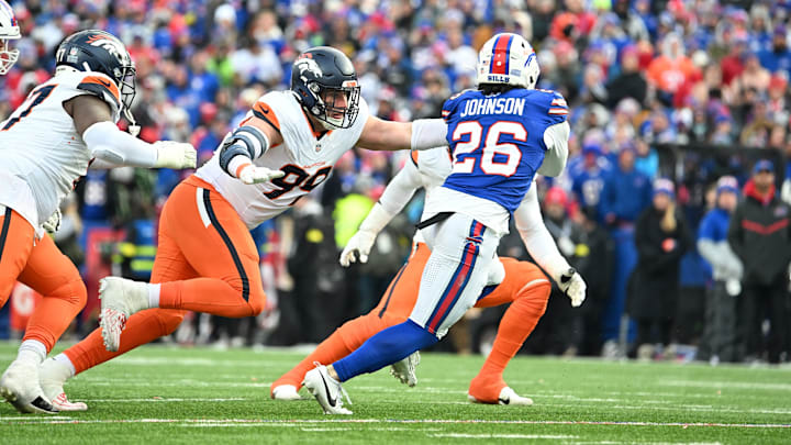 Jan 12, 2025; Orchard Park, New York, USA; Buffalo Bills running back Ty Johnson (26) runs for a gain as Denver Broncos defensive end Zach Allen (99) tackles during the fourth quarter in an AFC wild card game at Highmark Stadium. 