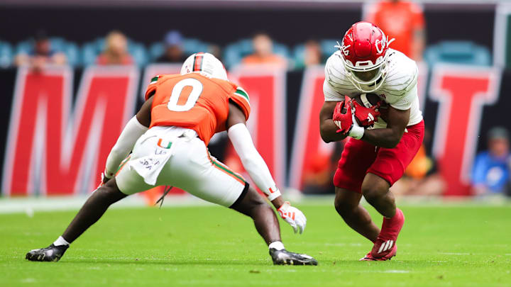 Nov 18, 2023; Miami Gardens, Florida, USA; Louisville Cardinals running back Jawhar Jordan (25) runs with the football against Miami Hurricanes cornerback Te'Cory Couch (0) during the second quarter at Hard Rock Stadium. Mandatory Credit: Sam Navarro-Imagn Images