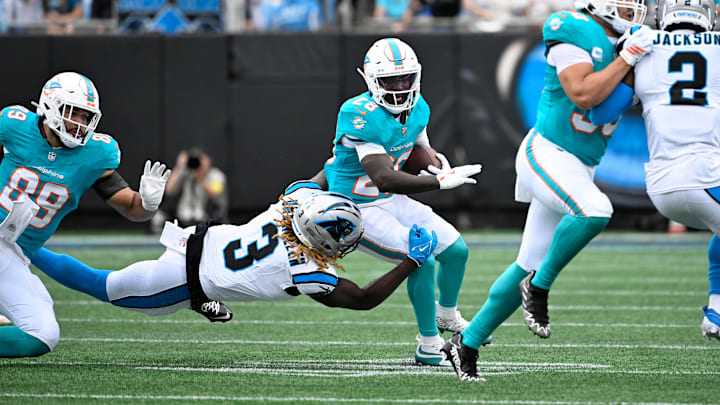 Oct 5, 2025; Charlotte, North Carolina, USA; Miami Dolphins running back De'Von Achane (28) with the ball as Carolina Panthers linebacker Princely Umanmielen (3) defends in the first quarter at Bank of America Stadium. 
