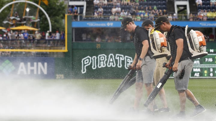Jun 28, 2025; Pittsburgh, Pennsylvania, USA;  The PNC Park grounds crew attempts to blow rain off of the playing surface in order to resume the game against the New York Mets after a rain delay halted play in the second inning at PNC Park. Mandatory Credit: Charles LeClaire-Imagn Images
