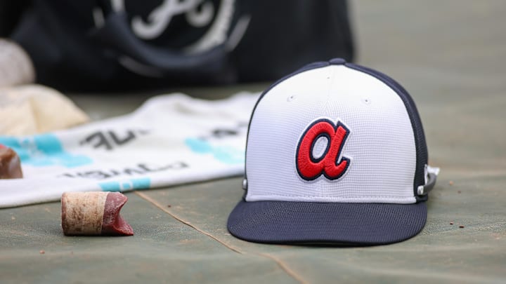 Apr 10, 2024; Atlanta, Georgia, USA; A detailed view of an Atlanta Braves hat on the field during batting practice at Truist Park. The game against the New York Mets was postponed due to impending weather. Mandatory Credit: Brett Davis-Imagn Images