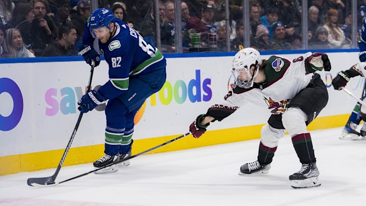Jan 18, 2024; Vancouver, British Columbia, CAN; Arizona Coyotes forward Matias Maccelli (63) stick checks Vancouver Canucks defenseman Ian Cole (82) in the second period at Rogers Arena. Mandatory Credit: Bob Frid-Imagn Images