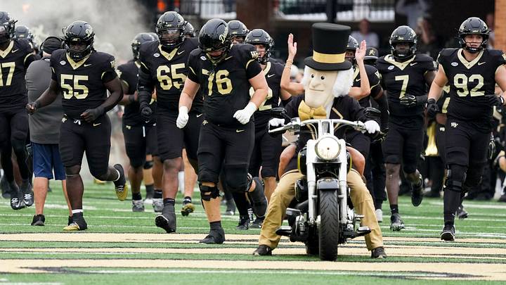Oct 3, 2026; Winston-Salem, North Carolina, USA; Wake Forest Demon Deacons mascot leads the team onto the field along with Tracy Piccolo-Dolby during the first half against the Stanford Cardinal at Allegacy Federal Credit Union Stadium. Mandatory Credit: Jim Dedmon-Imagn Images Oct 3, 2026; Winston-Salem, North Carolina, USA; Wake Forest Demon Deacons mascot leads the team onto the field along with Tracy Piccolo-Dolby during the first half against the Stanford Cardinal at Allegacy Federal Credit Union Stadium. Mandatory Credit: Jim Dedmon-Imagn Images