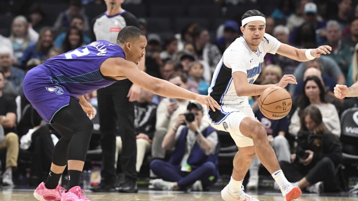 Orlando Magic guard Anthony Black (0) and Charlotte Hornets forward Grant Williams (2) go after a loose ball during the first half at the Spectrum Center. 