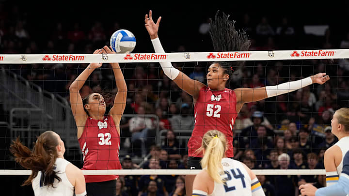 Wisconsin Badgers outside hitter Grace Egan (32) and middle blocker Carter Booth (52) jump to block the hit. Wisconsin Badgers outside hitter Grace Egan (32) and middle blocker Carter Booth (52) jump to block the hit.