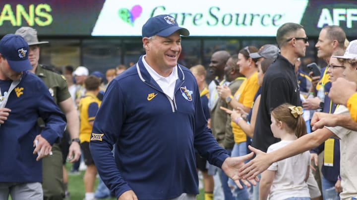 Sep 27, 2025; Morgantown, West Virginia, USA; West Virginia Mountaineers head coach Rich Rodriguez walks on the field and greets fans before their game against the Utah Utes at Milan Puskar Stadium. Mandatory Credit: Ben Queen-Imagn Images