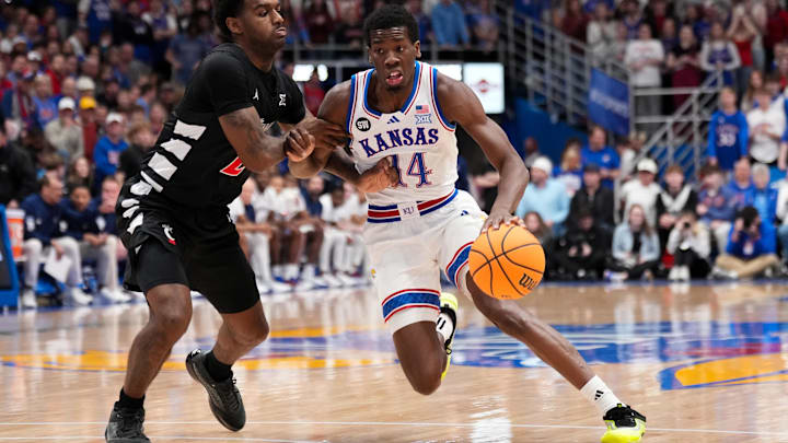 Feb 21, 2026; Lawrence, Kansas, USA; Kansas Jayhawks guard Melvin Council Jr. (14) dribbles the ball as Cincinnati Bearcats guard Jizzle James (2) defends during the first half of the game at Allen Fieldhouse. Mandatory Credit: Denny Medley-Imagn Images