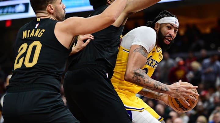 Oct 30, 2024; Cleveland, Ohio, USA; Los Angeles Lakers center Anthony Davis (3) drives to the basket against Cleveland Cavaliers forward Georges Niang (20) and center Jarrett Allen (31) during the second half at Rocket Mortgage FieldHouse. Mandatory Credit: Ken Blaze-Imagn Images