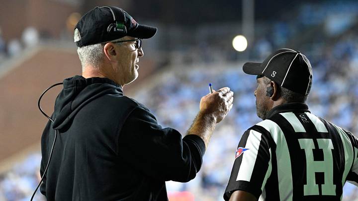 Stanford Cardinal head coach Frank Reich with an official in the third quarter at Kenan Stadium.
