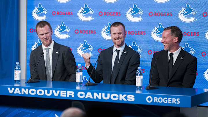 May 14, 2026; Vancouver, BC, Canada; The Vancouver Canucks promoted Henrik Sedin (left) and his twin brother Daniel Sedin (center) to co-presidents and Ryan Johnson (right) was named the Canucks new general manger during a press conference at Rogers Arena. Mandatory Credit: Bob Frid-Imagn Images