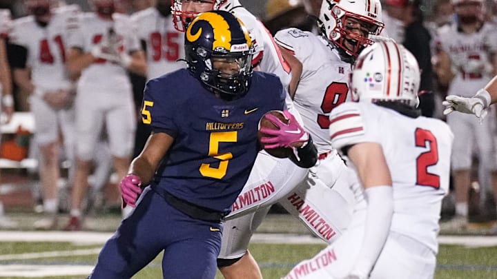 Marquette running back Tommy Novotny (5) weaves through the Sussex defenders during a Greater Metro Conference game at Hart Park on Friday, Oct.11, 2024.