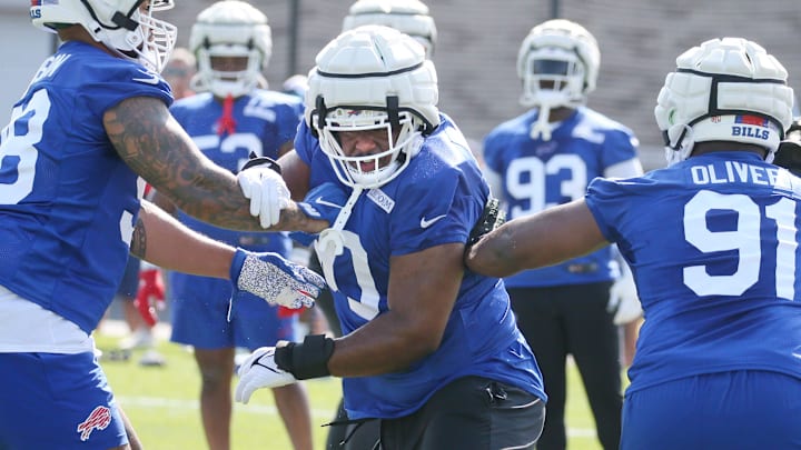 Bills defensive tackle DeWayne Carter splits between Austin Johnson, left, and Ed Oliver during defensive line drills.
