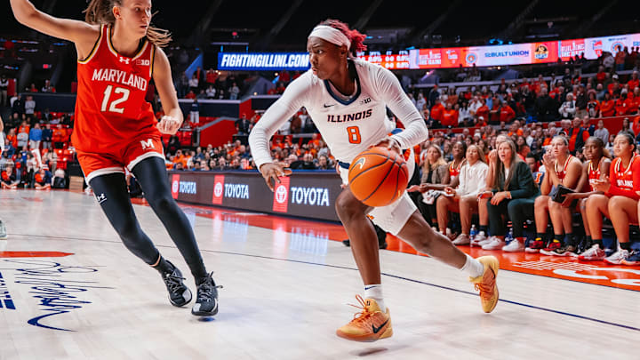 Illinois guard Jasmine Brown-Hagger (8) drives on a Maryand defender in the Illini's 73-70 win over the Terrapins on New Year's Day at the State Farm Center in Champaign, Illinois.