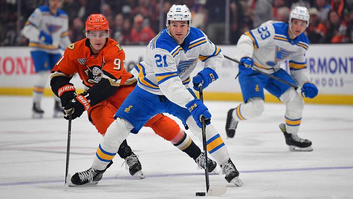 Apr 3, 2026; Anaheim, California, USA; St. Louis Blues right wing Jimmy Snuggerud (21) moves the puck ahead of Anaheim Ducks center Leo Carlsson (91) during the first period at Honda Center. Mandatory Credit: Gary A. Vasquez-Imagn Images