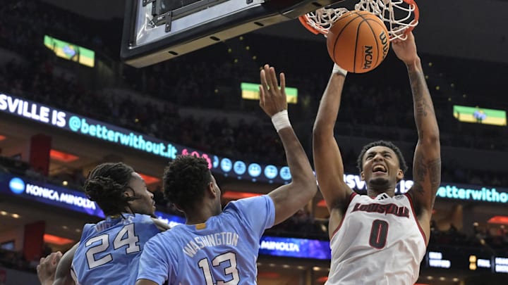 Jan 1, 2025; Louisville, Kentucky, USA;  Louisville Cardinals forward James Scott (0) dunks against North Carolina Tar Heels forward Jae'Lyn Withers (24) and  forward Jalen Washington (13) during the second half at KFC Yum! Center. Mandatory Credit: Jamie Rhodes-Imagn Images