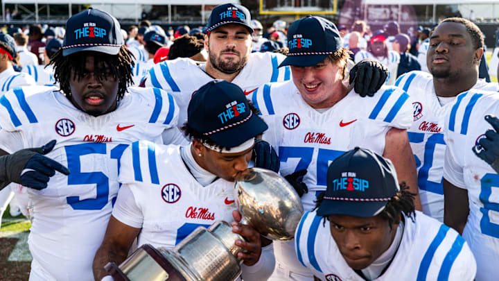 Ole Miss quarterback Trinidad Chambliss (6) kisses the Golden Egg trophy while posing for a picture with teammates after a college football game between Mississippi State and Ole Miss at Davis Wade Stadium in Starkville, Miss., on Friday, Nov. 28, 2025. Ole Miss defeated Mississippi State 38-19 in the Egg Bowl.