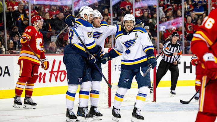 Dec 5, 2024; Calgary, Alberta, CAN; St. Louis Blues left wing Pavel Buchnevich (89) celebrates a goal with left wing Jake Neighbours (63) and center Robert Thomas (18) against the Calgary Flames during the third period at Scotiabank Saddledome. Mandatory Credit: Brett Holmes-Imagn Images