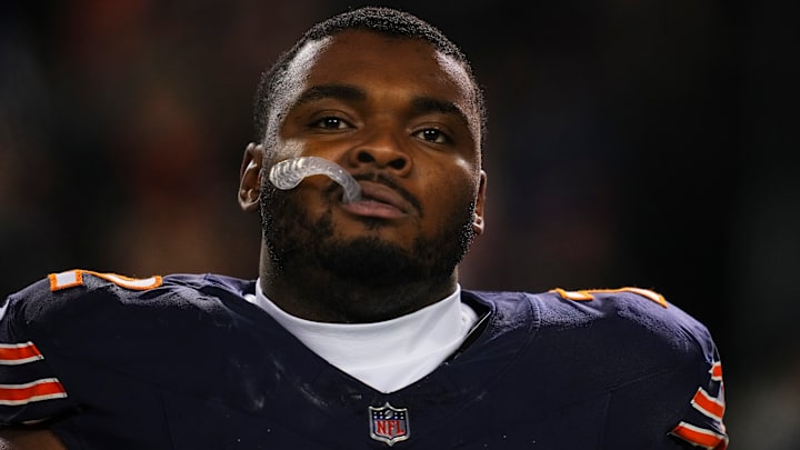 Chicago Bears offensive lineman Kiran Amegadjie watches a game from the sidelines.
