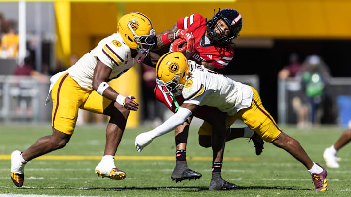 Oct 18, 2025; Tempe, Arizona, USA; Texas Tech Red Raiders wide receiver Caleb Douglas (5) is tackled by Arizona State Sun Devils defensive back Keith Abney II (1) and linebacker Jordan Crook (8) in the first half at Mountain America Stadium. Mandatory Credit: Mark J. Rebilas-Imagn Images Oct 18, 2025; Tempe, Arizona, USA; Texas Tech Red Raiders wide receiver Caleb Douglas (5) is tackled by Arizona State Sun Devils defensive back Keith Abney II (1) and linebacker Jordan Crook (8) in the first half at Mountain America Stadium. Mandatory Credit: Mark J. Rebilas-Imagn Images