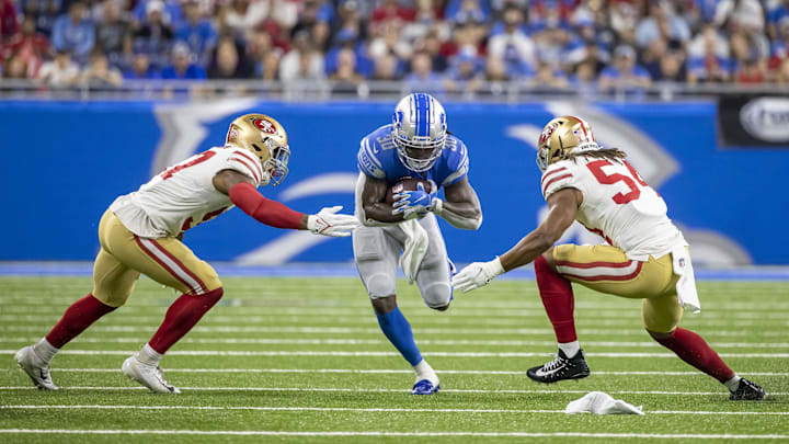Sep 12, 2021; Detroit, Michigan, USA; Detroit Lions running back Jamaal Williams (30) runs with the football between San Francisco 49ers linebacker Dre Greenlaw (57) and middle linebacker Fred Warner (54) in the first quarter at Ford Field. Mandatory Credit: David Reginek-Imagn Images Sep 12, 2021; Detroit, Michigan, USA; Detroit Lions running back Jamaal Williams (30) runs with the football between San Francisco 49ers linebacker Dre Greenlaw (57) and middle linebacker Fred Warner (54) in the first quarter at Ford Field. Mandatory Credit: David Reginek-Imagn Images