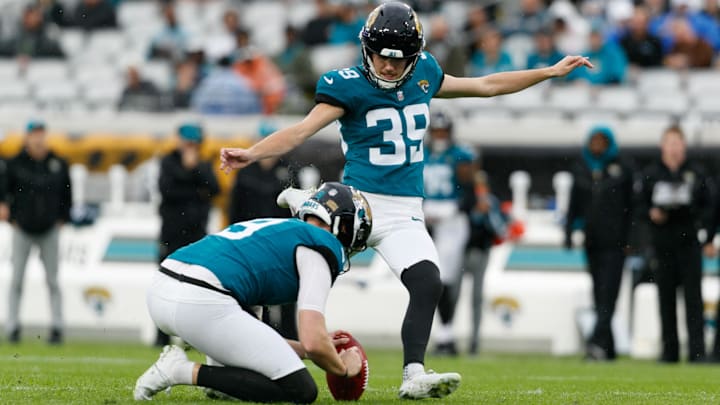 Dec 29, 2024; Jacksonville, Florida, USA; Jacksonville Jaguars punter Logan Cooke (9) holds the ball for kicker Cam Little (39) as he attempts a field goal against the Tennessee Titans during the first quarter at EverBank Stadium. Mandatory Credit: Morgan Tencza-Imagn Images
