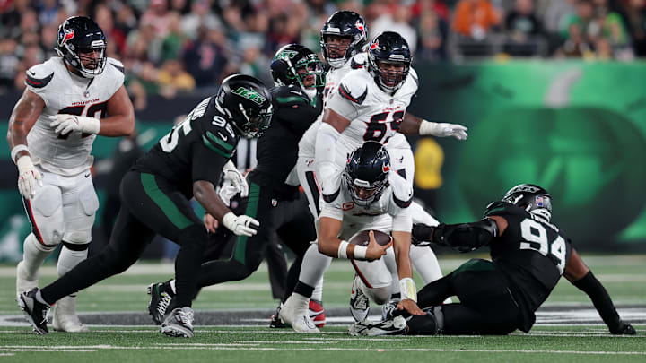 Oct 31, 2024; East Rutherford, New Jersey, USA; Houston Texans quarterback C.J. Stroud (7) is tackled by New York Jets defensive tackle Quinnen Williams (95) and defensive end Solomon Thomas (94) during the second quarter at MetLife Stadium. Mandatory Credit: Brad Penner-Imagn Images