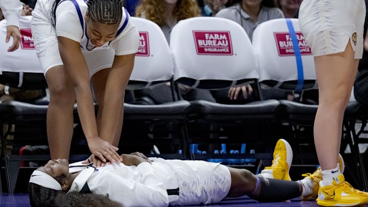 Nov 20, 2023; Baton Rouge, Louisiana, USA; LSU guard Flau'jae Johnson lies down and pretends to pass out from the excitement and need CPR from guard Mikaylah Williams.