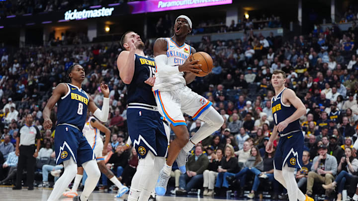 Nov 6, 2024; Denver, Colorado, USA; Oklahoma City Thunder guard Shai Gilgeous-Alexander (2) shoots the ball past Denver Nuggets center Nikola Jokic (15) in the second quarter at Ball Arena. Mandatory Credit: Ron Chenoy-Imagn Images