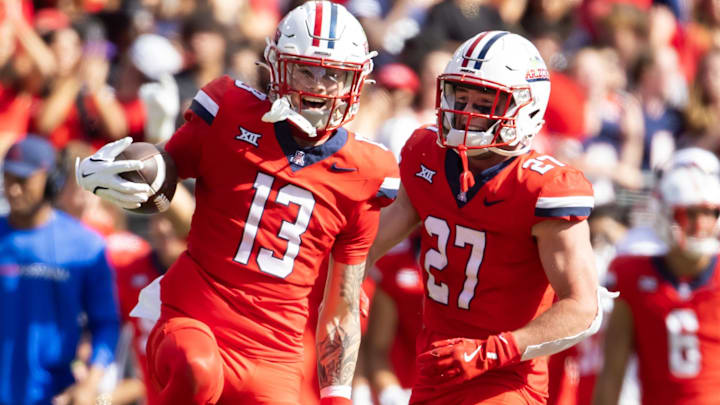 Oct 19, 2024; Tucson, Arizona, USA; Arizona Wildcats defensive back Jack Luttrell (13) celebrates with teammate Owen Goss (27) against the Colorado Buffalos at Arizona Stadium. Mandatory Credit: Mark J. Rebilas-Imagn Images