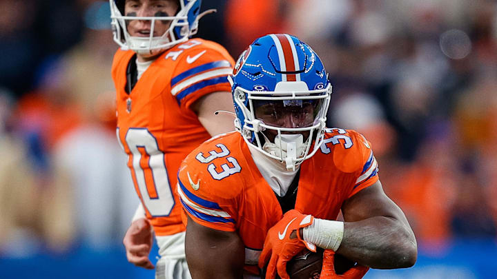 Jan 5, 2025; Denver, Colorado, USA; Denver Broncos running back Javonte Williams (33) runs the ball on a hand off from quarterback Bo Nix (10) in the fourth quarter against the Kansas City Chiefs at Empower Field at Mile High. Mandatory Credit: Isaiah J. Downing-Imagn Images